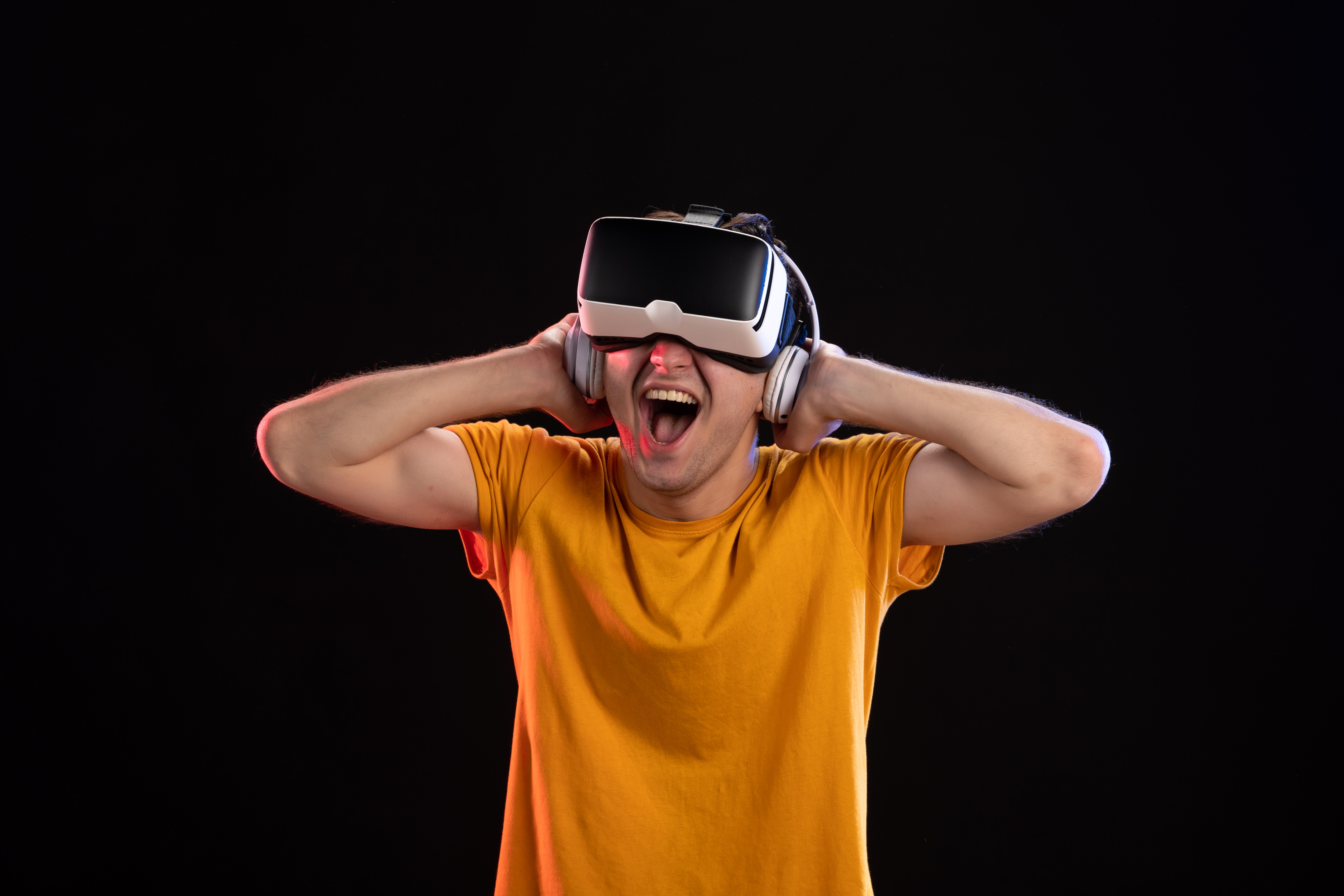 portrait young man playing vr headphones dark wall